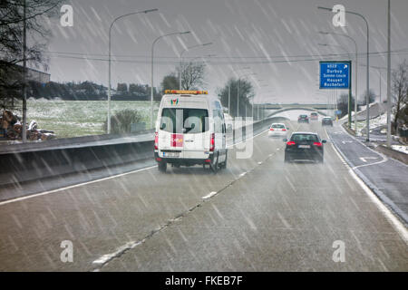 Van Autos fahren auf rutschigen Autobahn während Schneeregen verursacht winterlichen gefährliche Überholmanöver nassen Straßenverhältnissen im Winter / Frühjahr Stockfoto