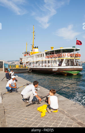 Männer Angeln am Kai und Passagier Fähre in Karakoy Cruise Terminal, Bosporus, Istanbul, Türkei Stockfoto