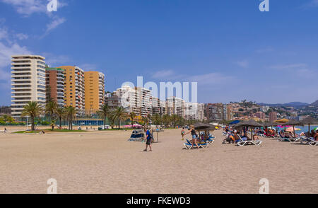 Liegestühle am Strand und Hochhäuser hinter am Playa De La Malagueta, Málaga, Costa Del Sol, Andalusien, Spanien Stockfoto