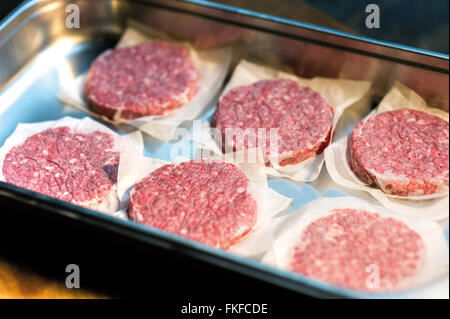 Burger Pattys in eine Schüssel geben Stockfoto