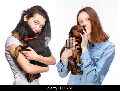 Schöne Frau hält Dobermann Hund Welpen auf ihren Händen, isoliert auf weiss Stockfoto