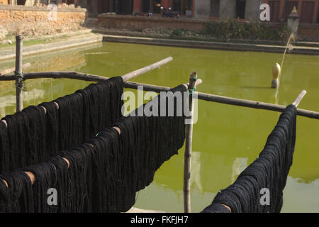 Gefärbten Garnen Trocknung bei den Wassertank auf Naga Pokhari, Bhaktapur, Nepal Stockfoto