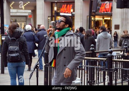 London, UK, März 2016, Dee Peacemaker Schnallen am Oxford Circus.Dee Peacemaker Afrika ist ein Edutainment-Reggae-Künstler aus Nigeria base UK. Er schreibt über soziale politische Ungerechtigkeit Afrika singt. Stockfoto