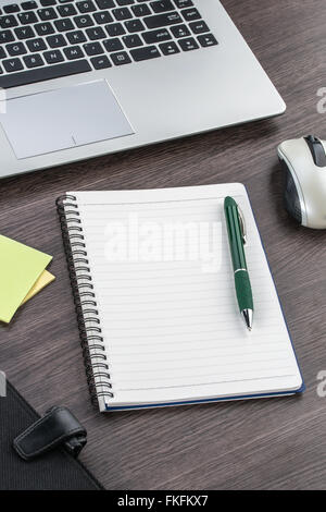 Laptop, Notizbuch und Stift mit Klebstoff Hinweis auf dem Schreibtisch Stockfoto