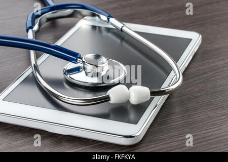 Digital-Tablette und Stethoskop auf Holz Schreibtisch Arzt Arbeitsplatz Stockfoto