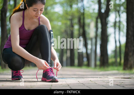 Junge Asiatin Läufer binden Schnürsenkel gesunden Lebensstil Joggen Stockfoto