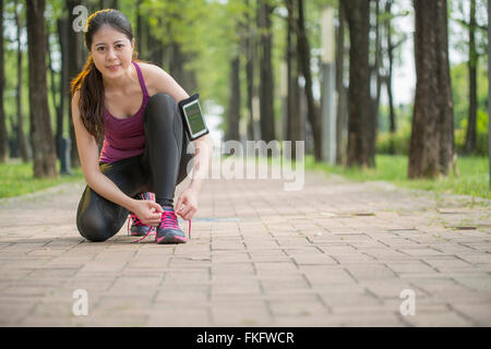 Junge Asiatin Läufer binden Schnürsenkel gesunden Lebensstil Joggen Stockfoto