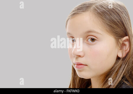 ein Porträt von Pre-Teenager-Mädchen auf grauem Hintergrund isoliert Stockfoto