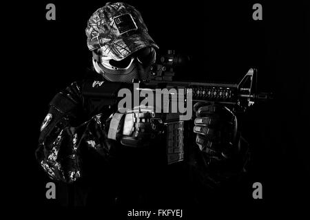 Airsoft Spieler mit Replik M4 in Aufnahmeposition. Stockfoto