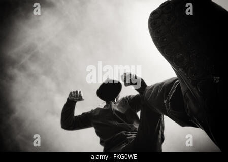 Gestanzt und überfallen durch aggressive gewalttätiger Mann in Kapuzenjacke auf Straße, des Opfers Pov Perspektive, monochromen Bild Stockfoto