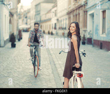 netter Junge auf einem Fahrrad kam durch eine schöne junge Frau, die aufgehört zu toothy Lächeln bei Cameta in einem alten europäischen Stadt center Stockfoto