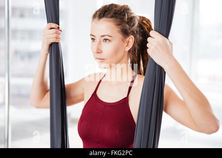 Hübsche junge Frau konzentriert mit Dreadlocks mit Hängematte im Yoga-studio Stockfoto