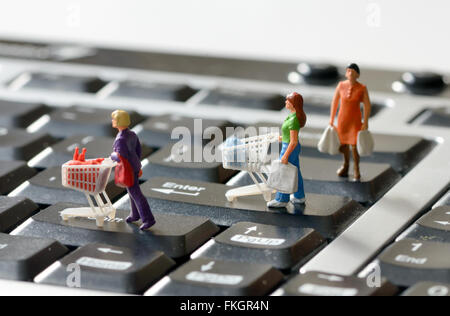 Miniatur-Shopper mit Einkaufswagen auf einer Computertastatur Stockfoto