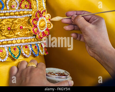 Bangkok, Thailand. 9. März 2016. Ein Arbeiter auf Thanon Bamrung Muang in Bangkok gilt einige faux Edelsteine für eine große buddhistische Statue, die zum Verkauf angeboten wird. Die Straße ist gesäumt von Werkstätten, die Statuen des Buddha und verehrten thailändischen buddhistischen Mönchen zu machen. Sobald etwas außerhalb Bangkoks Stadtmauern gelegen, ist es jetzt im Herzen der Stadt. Bildnachweis: Jack Kurtz/ZUMA Draht/Alamy Live-Nachrichten Stockfoto
