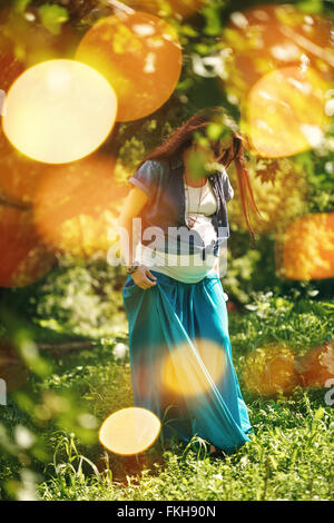 Ganzkörper Portrait schöne schwangere Frau, die Natur und die Sonne im Sommer Park genießen. Unscharfes Bild mit Bokeh Lights. Selectiv Stockfoto