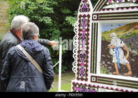 Besucher innehalten und betrachten eine traditionelle gut putzt in Bakewell Stadtzentrum im Peak District National Park England UK Stockfoto