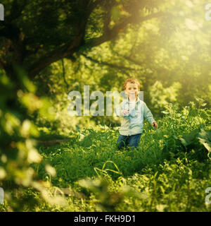 Glückliche Kindheit. Niedlichen kleinen Jungen Spaß in der Natur der Sommerpark. Süße Blonde Kind in Jeans Kleidung. Selektiven Fokus. Stockfoto