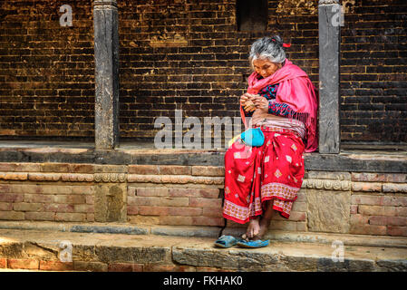 Alte Frau bittet in der Straße von Bandipur Stockfoto