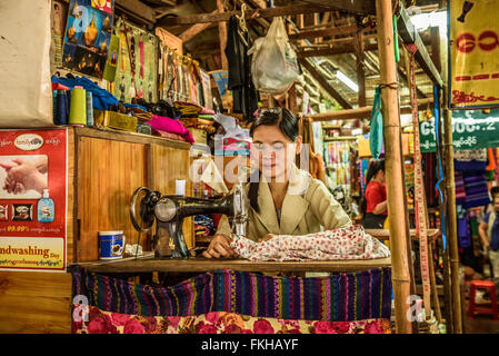 Junge asiatische Frau arbeitet an eine alte Nähmaschine auf einem lokalen Markt in Yangon Stockfoto