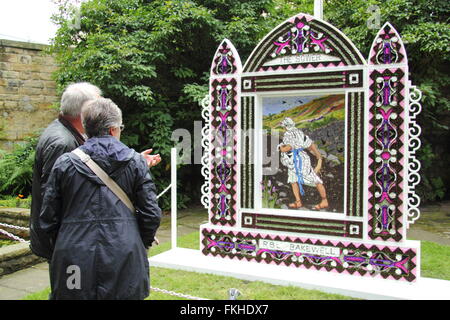 Besucher innehalten und betrachten eine traditionelle gut putzt in Bakewell Stadtzentrum im Peak District National Park England UK Stockfoto