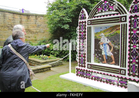 Besucher innehalten und betrachten eine traditionelle gut putzt in Bakewell Stadtzentrum im Peak District National Park England UK Stockfoto