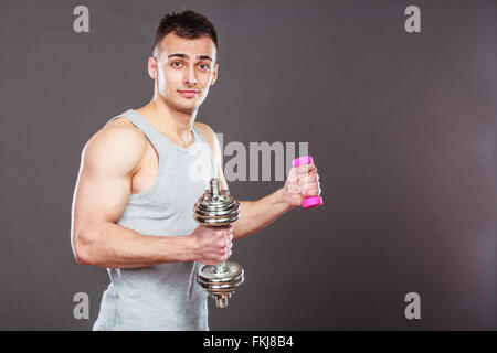 Sportlich fit Mann leichte und schwere Hanteln Gewichte zu heben. Jungen starken muskulösen Kerl training. Bodybuilding Übung. Stockfoto