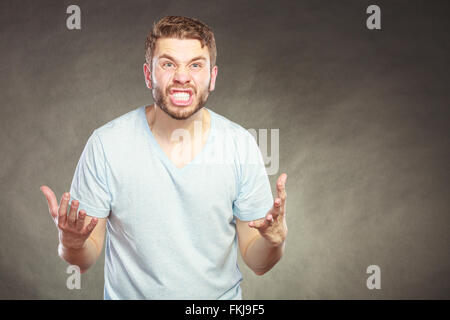 Porträt von verärgert angry wütender Mann im Hemd. Junger Mann im Studio auf schwarz. Gesichtsausdruck. Stockfoto