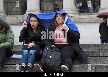 Westminster, London, UK. 9. März 2016. Menschen Schutz vor dem Regen auf dem Trafalgar Square an einem kalten tristen Tag in der Hauptstadt Credit: Amer Ghazzal/Alamy Live-Nachrichten Stockfoto