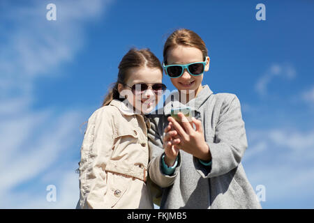glückliche Mädchen mit Smartphone unter Selfie im freien Stockfoto