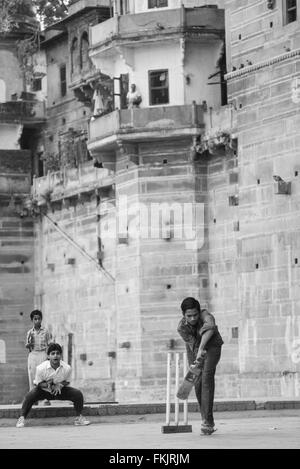 Lokalen Jungs über die Badegewässer Ghat, spielen beliebter Nationalsport Cricket bei Sonnenaufgang. Einen guten Hit und der Ball geht in den Fluss Stockfoto