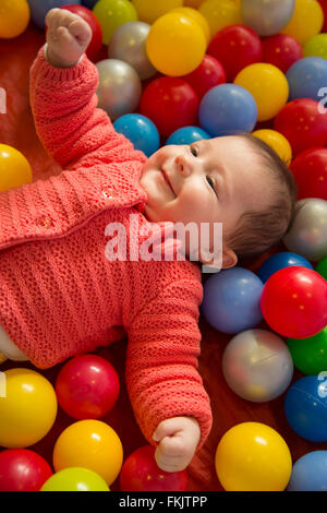 Babymädchen in einem sensorischen Bällebad Stockfoto