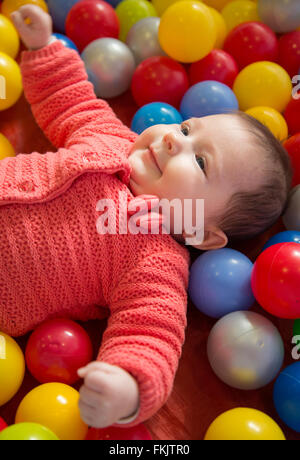 Babymädchen in einem sensorischen Bällebad Stockfoto