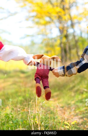 Nahaufnahme eines Spielzeug-Hasen in den Händen von zwei Kindern verwahrt Stockfoto