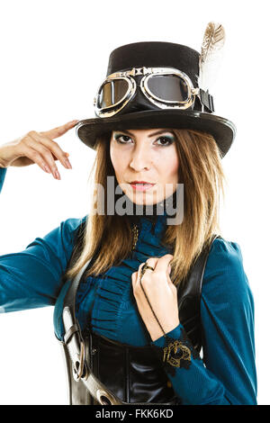 Junge Steampunk isoliert Mädchen auf ausgefallene Hut zu berühren weiß. Fantasie altmodisch mit stilvollen Topper und Goggle. Stockfoto