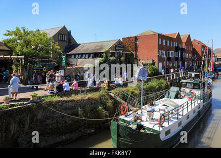 Boot am Fluss Stour mit Leuten außerhalb Fishermans Wharf auf The Quay in historischen Cinque Port Stadt von Sandwich Kent England UK Stockfoto