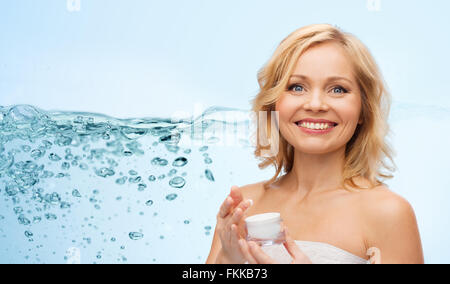 glückliche mittlere gealterte Frau mit Feuchtigkeitscreme Stockfoto