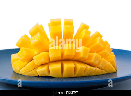 Halbe Mango-Frucht in Scheiben geschnitten in eine Igel-Form auf eine blaue Keramik-Platte Stockfoto