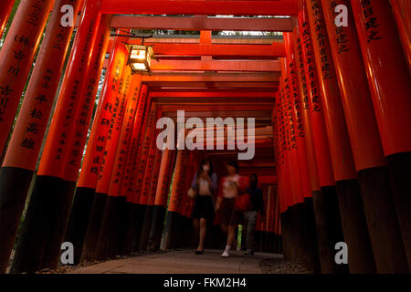 Touristen gehen unter Torii, Fushimi Inari-Taisha, Fushimi-Ku, Kyoto, Japan. Stockfoto