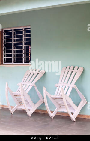 Traditionelle weiße Schaukelstühle, die auf der Veranda des Hauses in Vinales, Provinz Pinar del Rio, Kuba, Westindien und der Karibik gegen die Wand ausgeliehen wurden Stockfoto