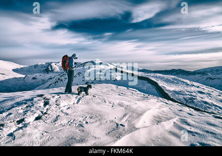 Ein Wanderer Überprüfung ihre Position in den Bergen auf einem GPS und Karte. Zusätzlichen Filmkorn und Farbe-Styling. Stockfoto