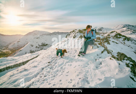 Ein Wanderer ruht auf den Bergen an der Spitze mit ihrem Hund im Vereinigten Königreich. Maserung und Farbe Styling angewendet Stockfoto