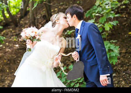 Braut und Bräutigam mit einem Schild in Herzform. Stockfoto