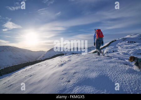 Wanderer zu Fuß durch den Schnee entlang Hartsop oben wie das Hart Crag führt. Englischen Lake District. Stockfoto