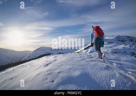 Wanderer zu Fuß durch den Schnee entlang Hartsop oben wie das Hart Crag führt. Englischen Lake District. Stockfoto