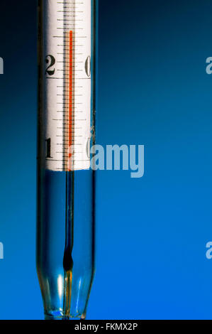 Das Thermometer auf dunkelblauem Hintergrund Stockfoto