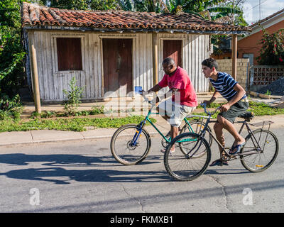 Zwei Radfahrer in Viñales, Kuba fahren auf einer Straße. Ein Männchen und ein Teenager. Stockfoto