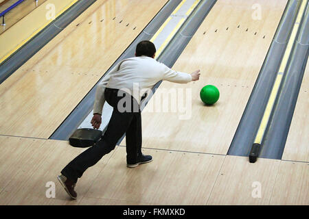 Grüne Kugel gleiten auf einem Pfad im bowling Stockfoto