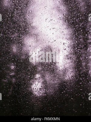 Regentropfen auf Fenster Moveing Zug, Hintergrund aus Fokus Bäume bilden. Stockfoto