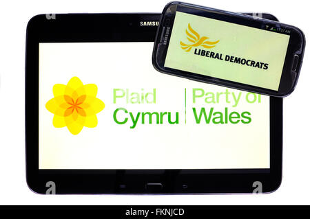 Plaid Cymru und Lib Dem Logos auf den Bildschirmen der ein Tablet und Smartphone vor einem weißen Hintergrund angezeigt. Stockfoto