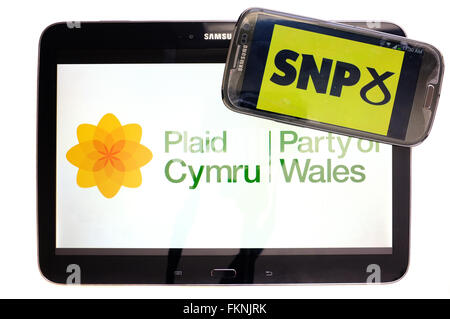 Das Plaid Cymru und SNP-Logos auf den Bildschirmen der ein Tablet und Smartphone vor einem weißen Hintergrund angezeigt. Stockfoto